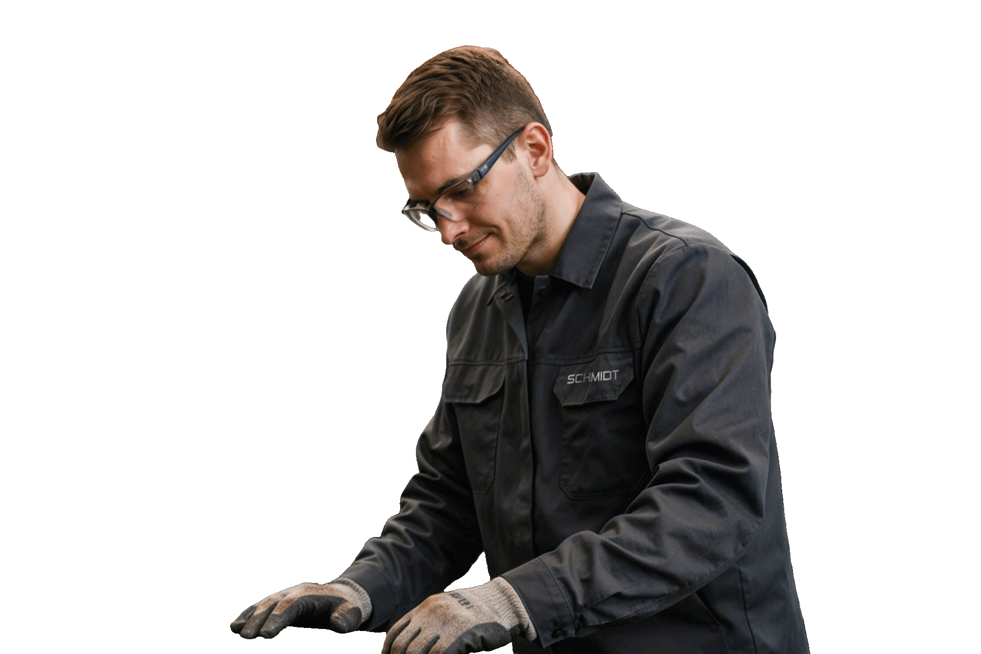 Mitarbeiter in grauer Arbeitsjacke arbeitet konzentriert an einem Metallbauteil.