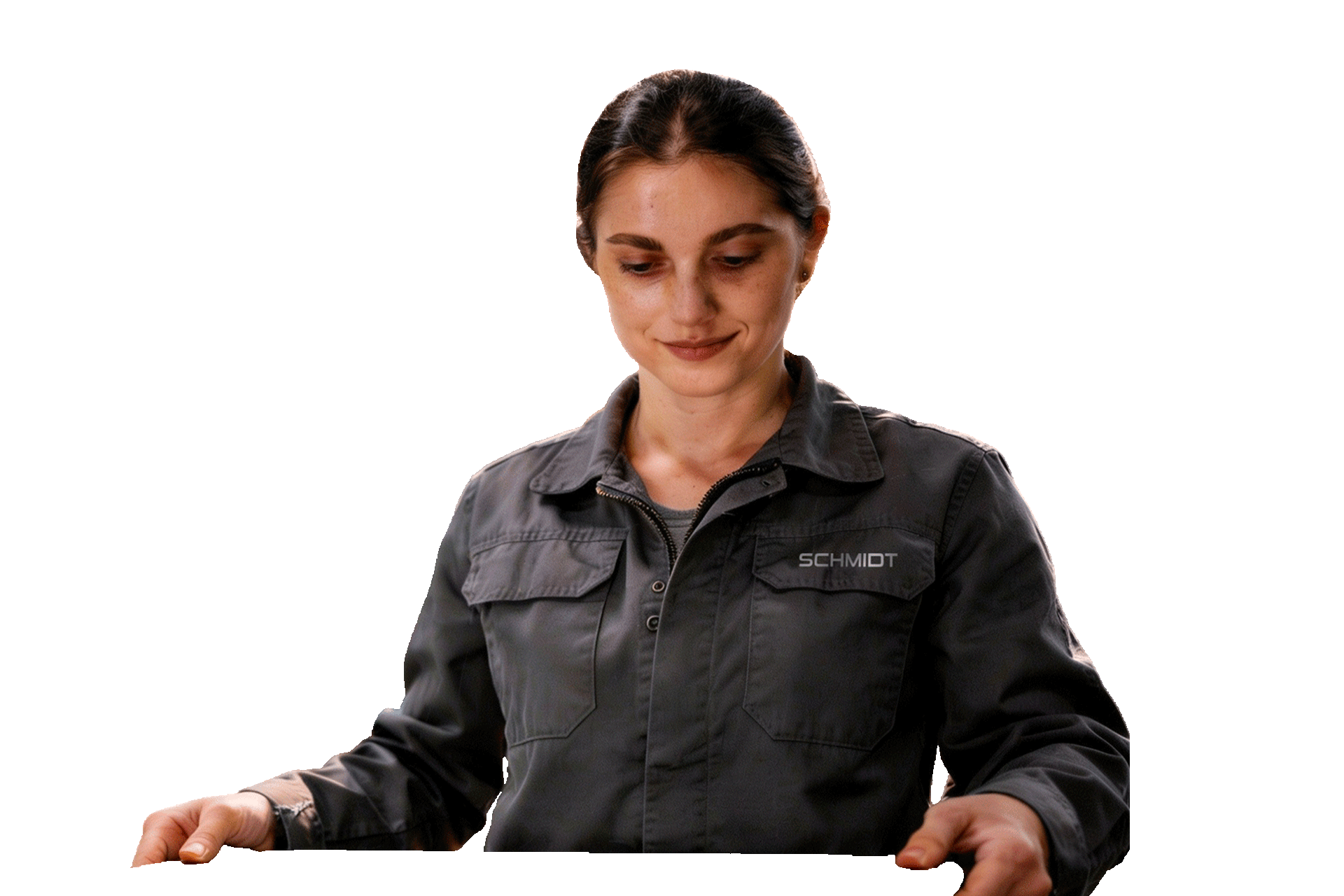 Frau in Arbeitskleidung steht frontal vor hellem Hintergrund und schaut nach unten.